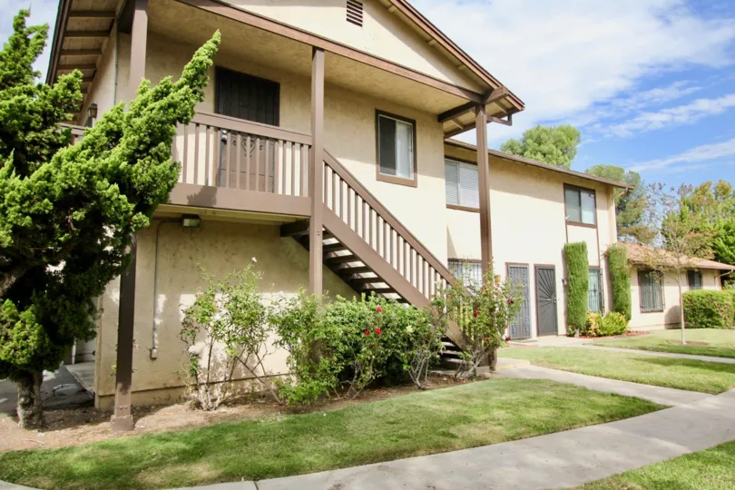 A sunny day in the area of Carefree South, outside, condos, stairs, trees, windows, flowers