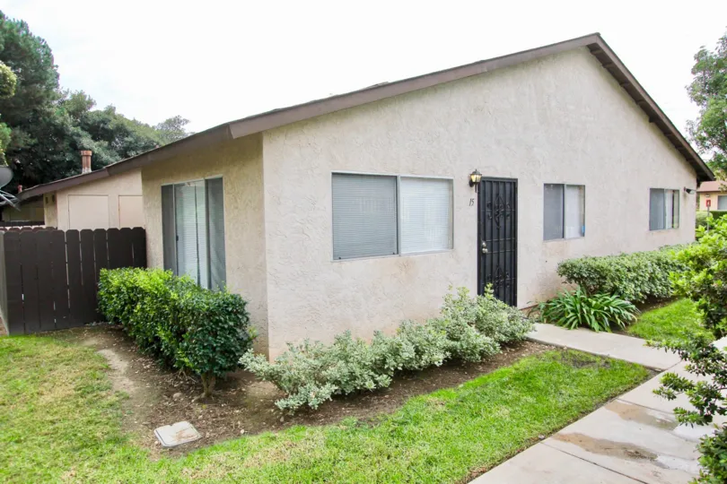 Bungalow style home on a wide lot with detached garage and shrubs with decent sized windows in Hidden Valley