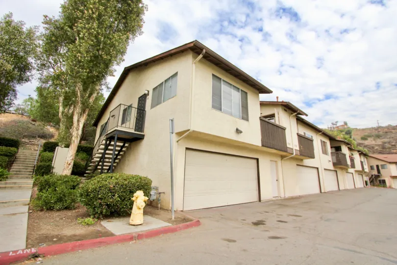 A sunny day in the area of Hidden Valley, outside, condos, balcony, trees, stairs, garage