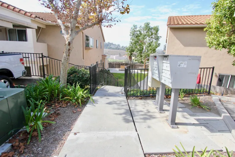 A sunny day in the area of Quarry Palms, outside, truck, sidewalk, stairs, fence, condos