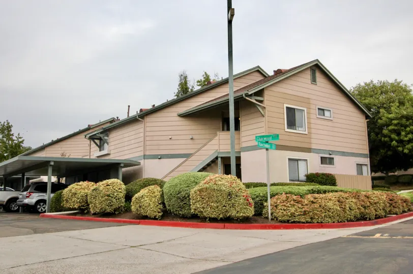 Ranchwood Park apartments with covers for the cars and some colorful bushes