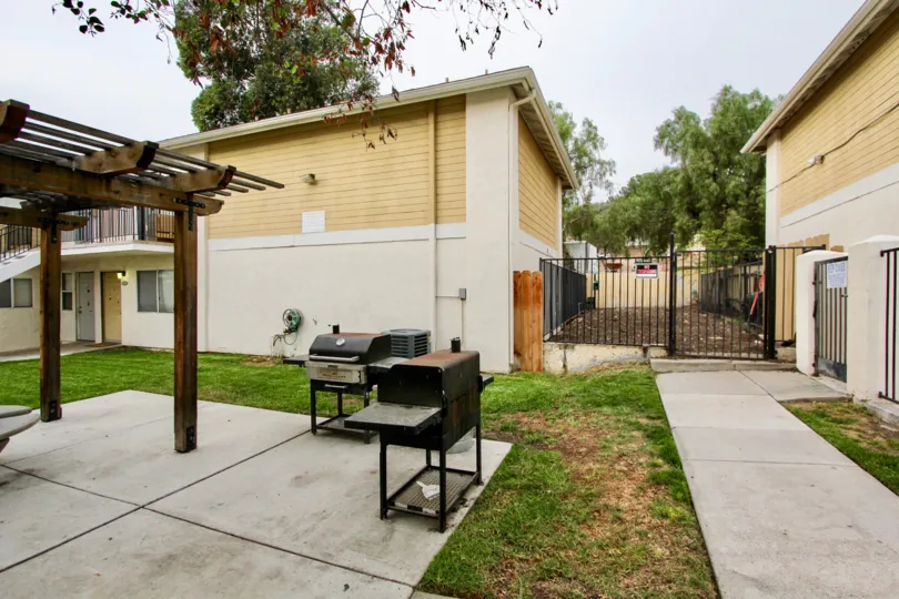 Concrete patio and walkways in a private fenced in area with barbeques and pergola in Spring Valley