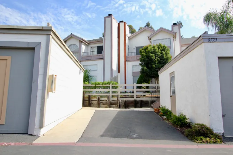 Two garages sit across a gate from a row of townhomes in the Spring Canyon community in Spring Valley California