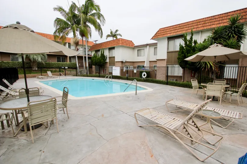 A small pool with wooden chairs in the Terraza community.