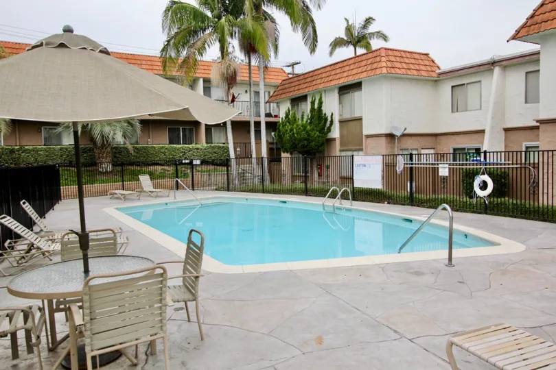 THE BUNGALOW IN THE TERRAZA WITH THE SWIMMING POOL, TABLES, UMBRELLA, PLANTS, TREES