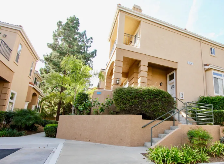 A set of stairs leads to a white door on a condo at Avanti condos