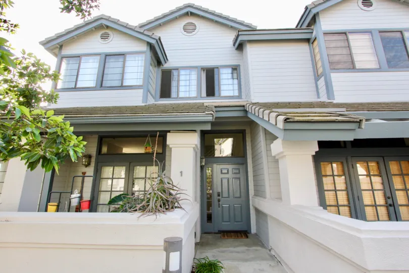 Traditional cottage styling townhome with siding and privacy walls at Cambridge Terrace