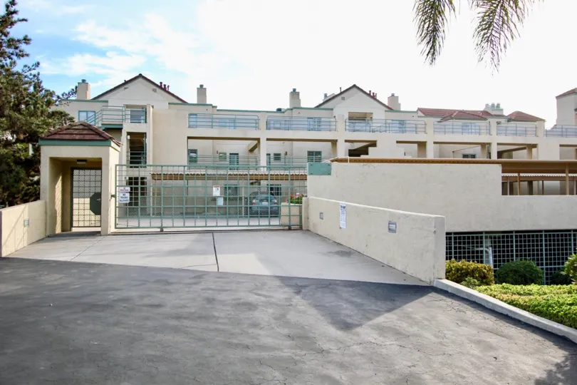 Entrance of the building with Blue gate with trees and plants surrounding in La Jolla City Club