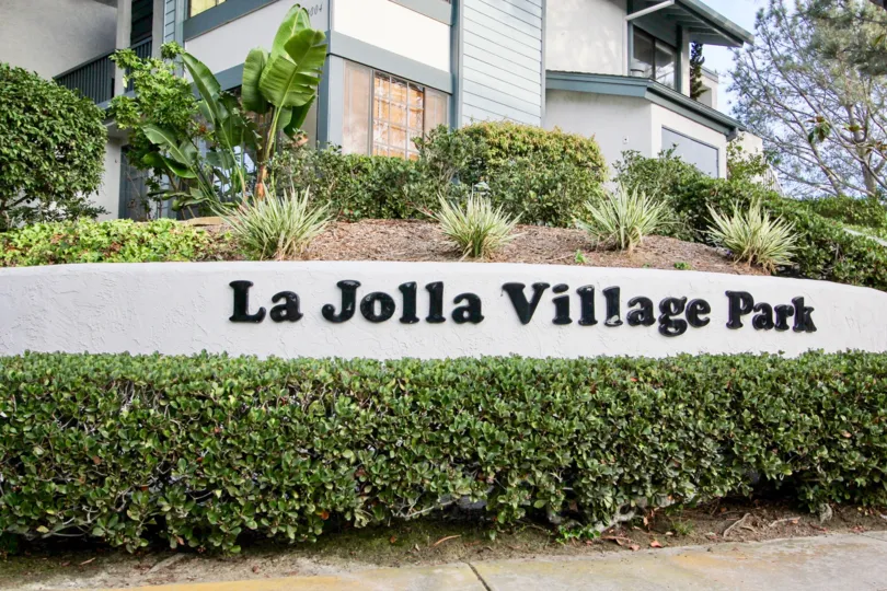 The sign at the entrance of La Jolla Village park showing the location name with attractive landscaping.