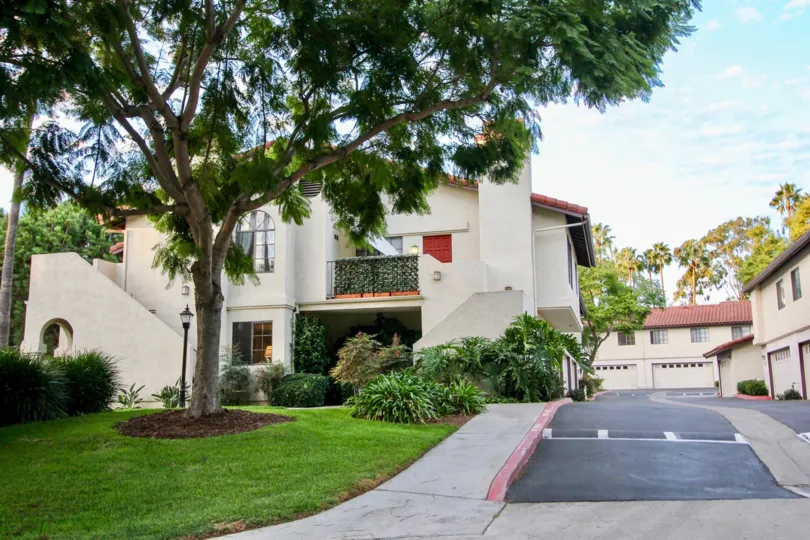 Parking lot entry, meticulous lawn, and plenty of topiaries at Las Palmas in University City, California.