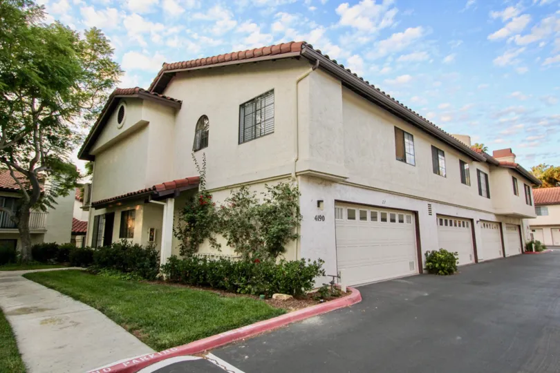 Two-story house with multiple parking garages and sidewalk, located in Las Palmas, University City, California.