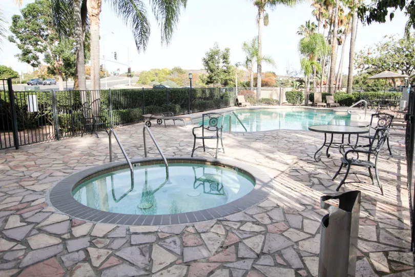 Cloudless skies overlooking pool area with lounge chairs and tables at Lecera.