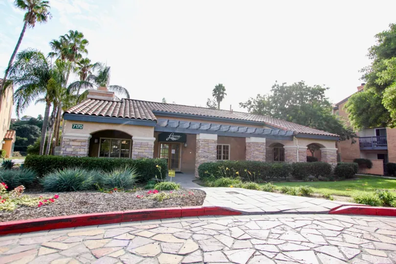 Single story home at the end of a driveway of stone in University City CA at Lucera