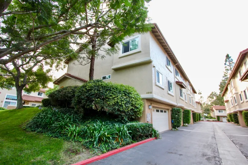 A view of the exterior at the Madrid community showing the rear of apartment units with private garages and driveway.