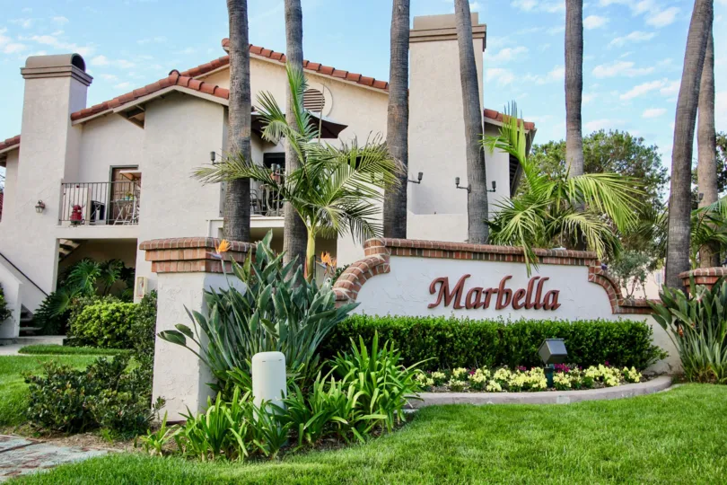 Decorated combound wall with letters MARBELLA with trees plants and flower around in building in Marbella
