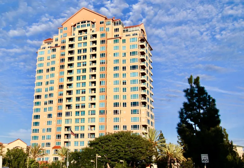 High rise residential building next to tall trees at Pacific Regent La Jolla in University City California