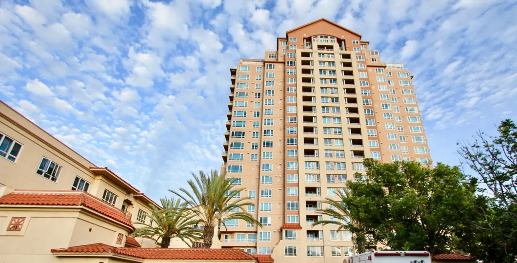 An exterior view of the Pacific Regent La Jolla high rise apartment building on a sunny day.