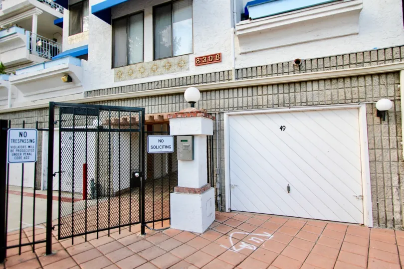 A security gate with signs barring entryway at Pines of La Jolla