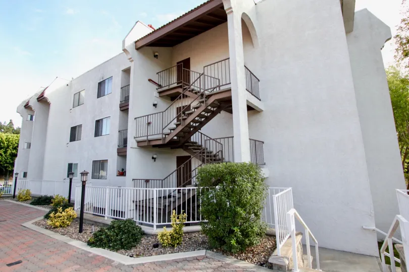 A white house with a staircase up to the third floor in Regency Villas