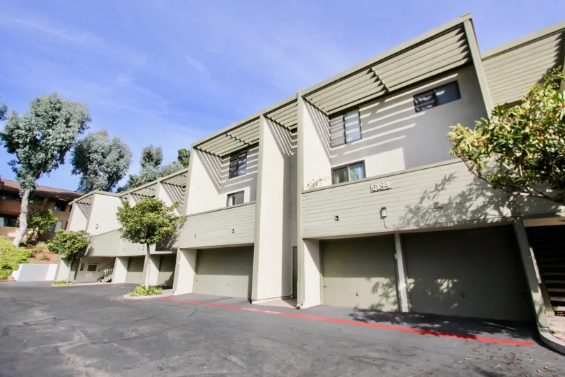 Three story residential units with attached garages near driveway at The Park i University City California.