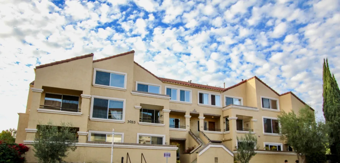 Three story, light yellow building with apartments in The Venetian, University City, California.