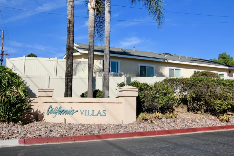 A beautiful tan sign with vibrant blue letters for the entrance of California Villas in Vista, California