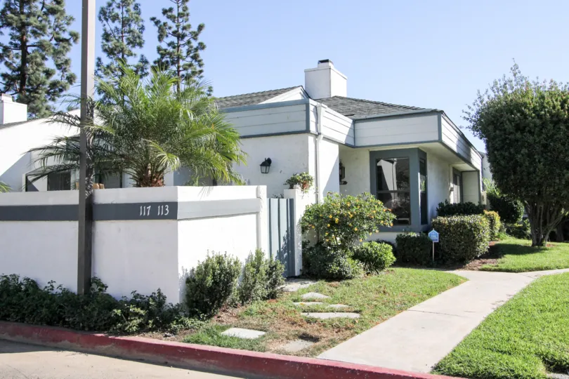 Curbside picture of home with white walls and blue trimming in Vista, CA