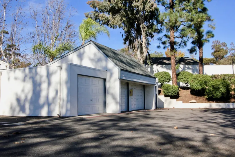 A sunny day featuring a garage and parking lot in the Copper Hill Community in Vista, California.