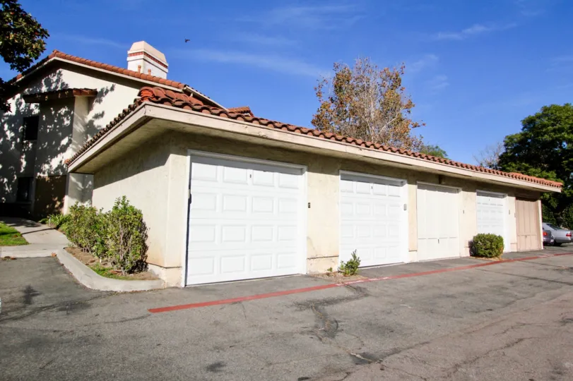 A sunny day at Shadowridge Glen showing four garage doors and a large driveway