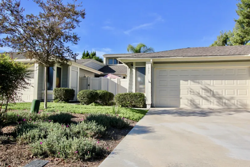 Front of house with big garage door and little plants in front yard, and two little tress in the Shadowridge Greens