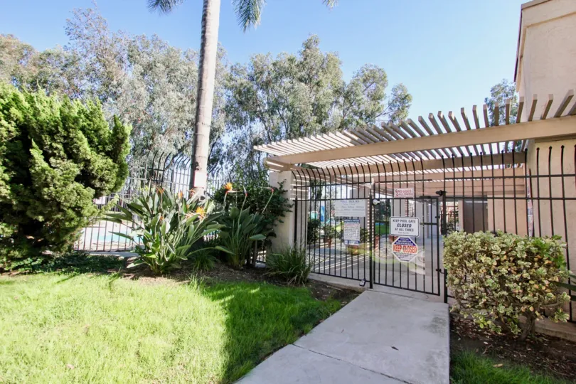Pink, fenced community in tropical paradise with meticulous landscaping.