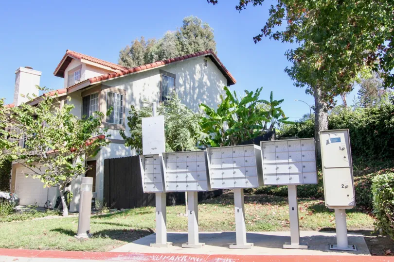 A row of mailboxes with some trees and houses behind it during a sunny day in Vista Knolls, Vista, CA