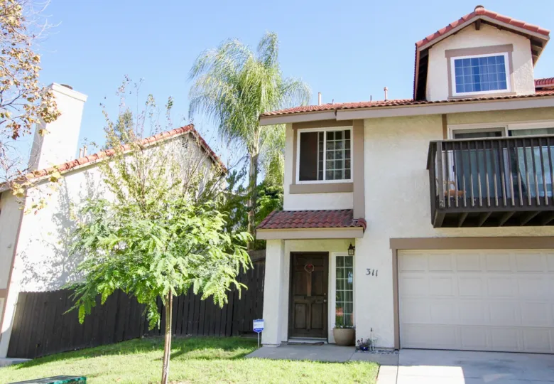 A small tree sits in the lawn of a townhouse at Vista Knolls