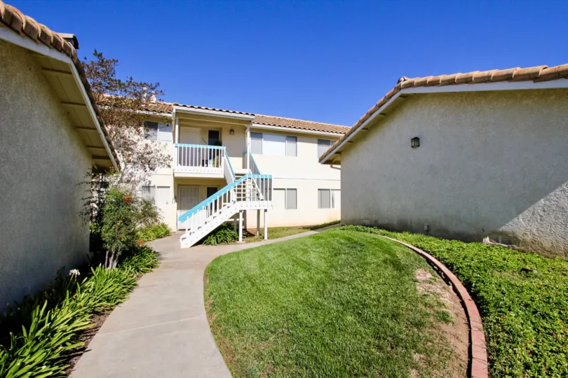 sunny day with clear blue skies featuring the courtyard and townhomes of the Vista Palomar in Vista California