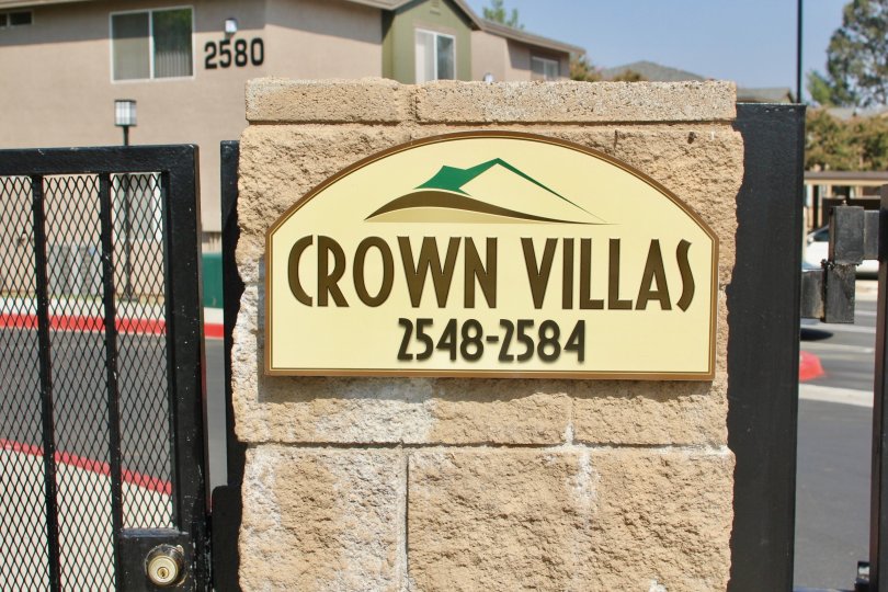 An emblem of a mountain sits on a sign at the Crown Villas community.