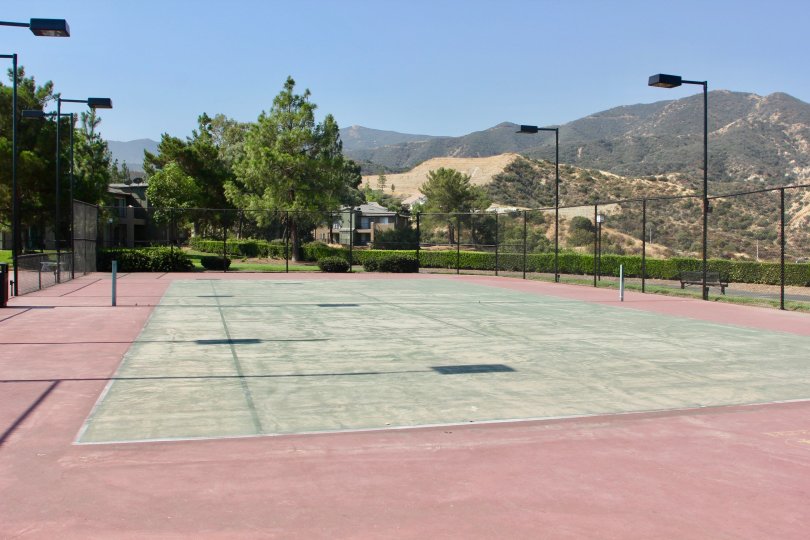 playing ground place to be relaxed by playing games and covered with mountainsand full of tree and grasses