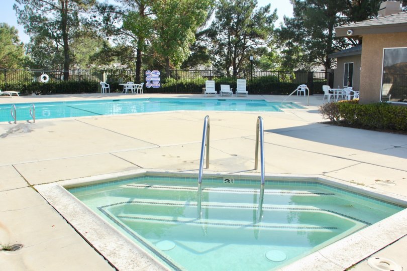 A glistening blue swimming pool and hot tub inside Crown Villas.