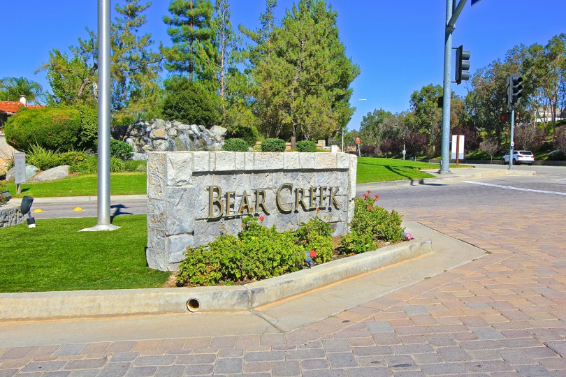 A sunny day showcasing the flowery entrance to the Fairway Estates at Bear Creek community.