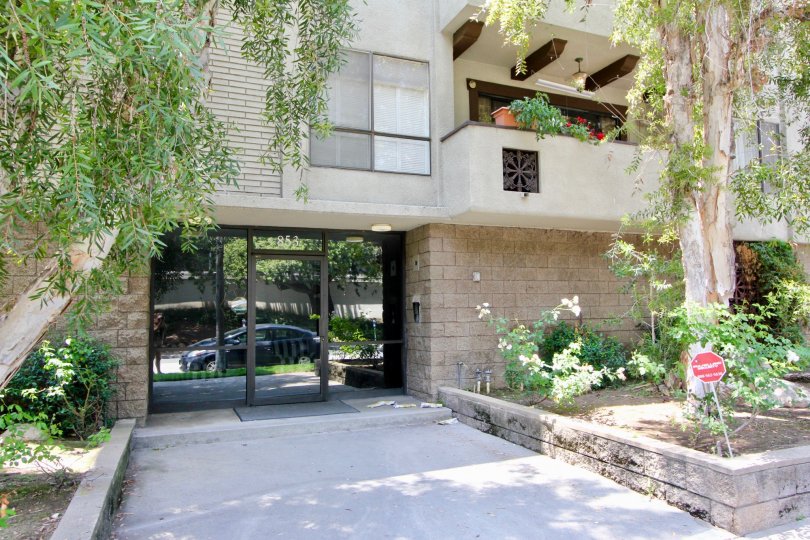 entry of a large house in California with glass doors and plants