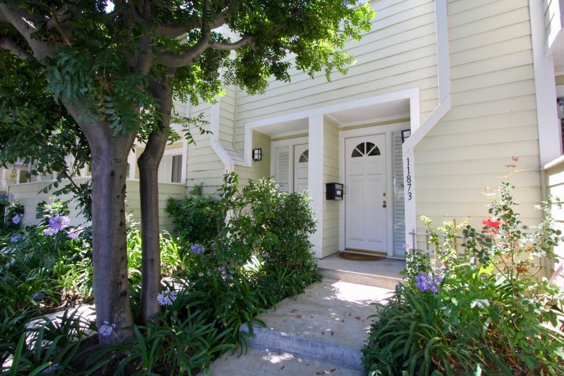 A sunny day in the Nebraska Manor Townhomes Townhomes a beautiful house and trees.