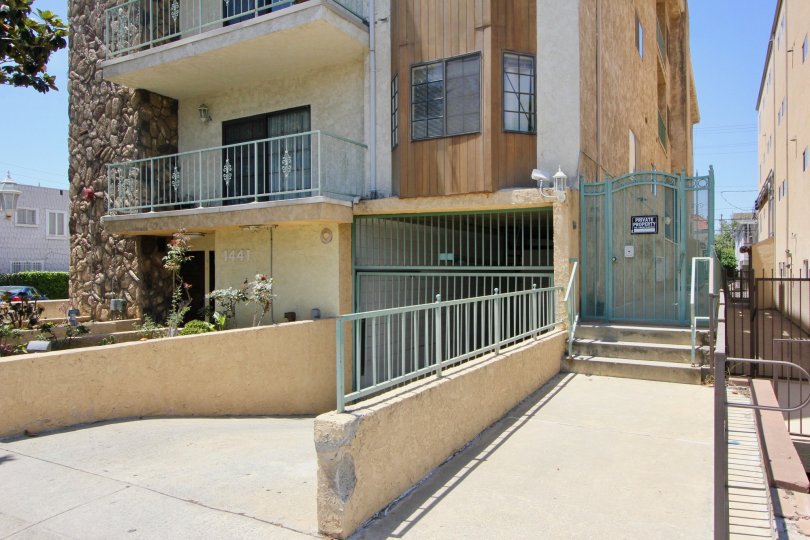 Underground parking area with fences and rocky wood stucco outside area on the building