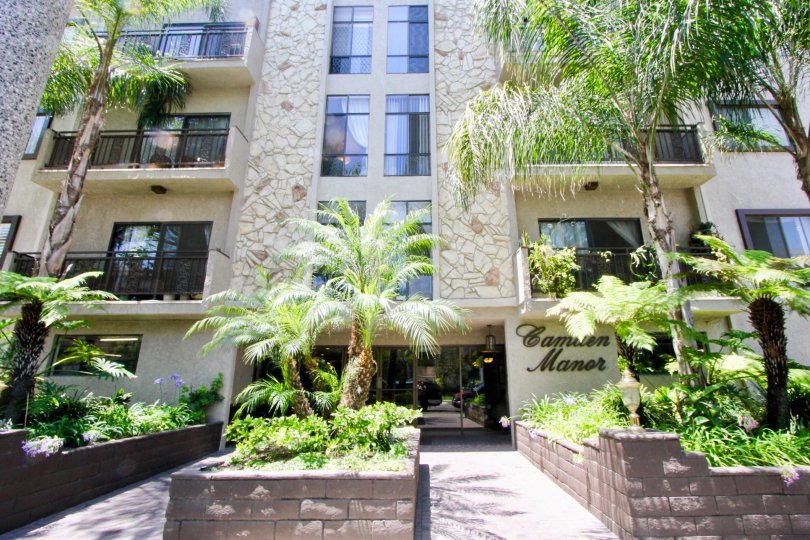 A sunny day the Camden Manor is looking so good the windows and doors are made up of glass the green leafy trees and plants in good atmosphere