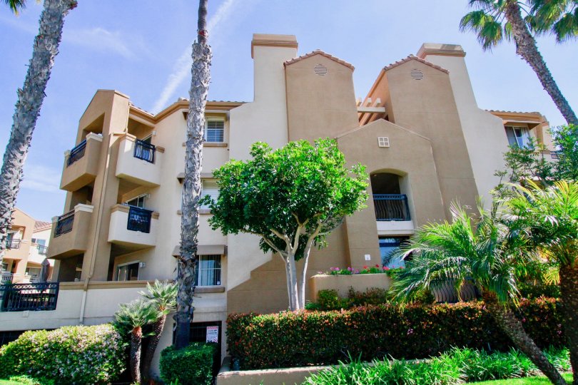 THE BUILDING LOOKS LIKE A BIG BUNGALOW AND MORE TREES AND PLANTS IN FRONT OF THE BUILDING IT HAS THREE FLOORS AND BALCONY.