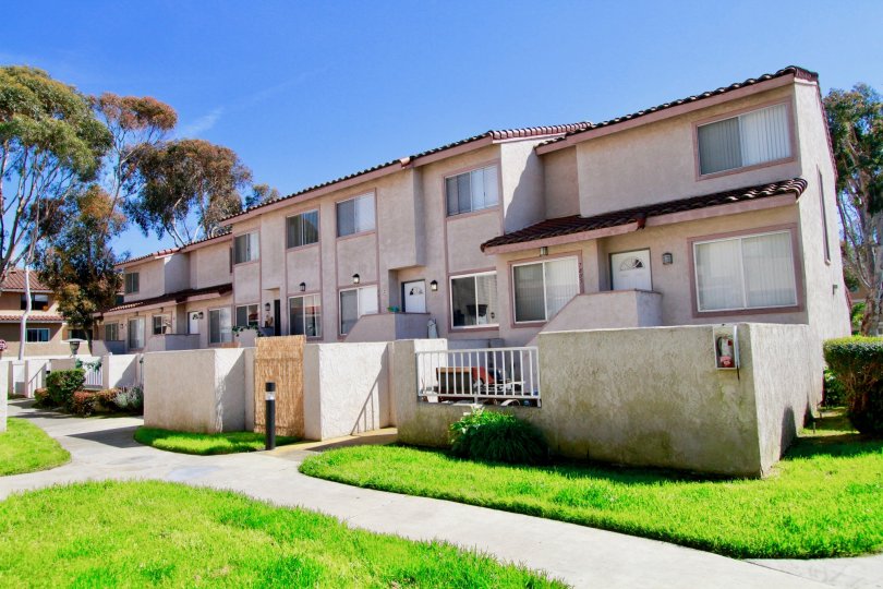 Multi level residential building with green grass on front yard in Seaside Village community.