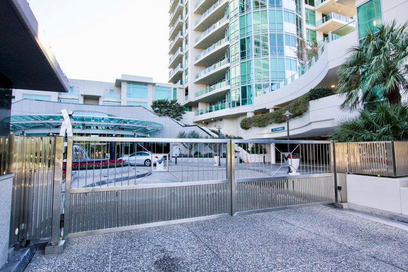 A gated driveway in the Marque at Park Place community with tall buildings.