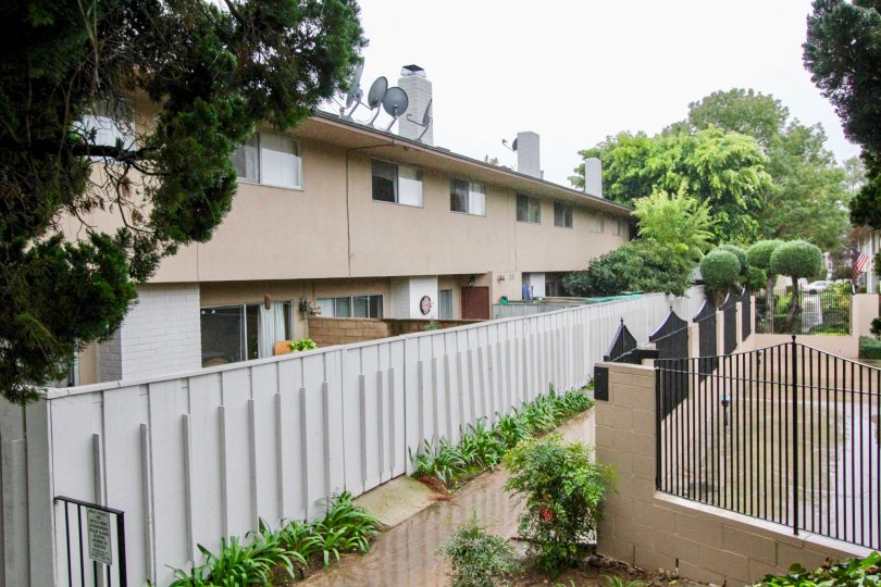 THE HOUSE IN THE WOODBRIDGE Townhouse WITH THE DISH ANTENNAS, PLANTS, TREES