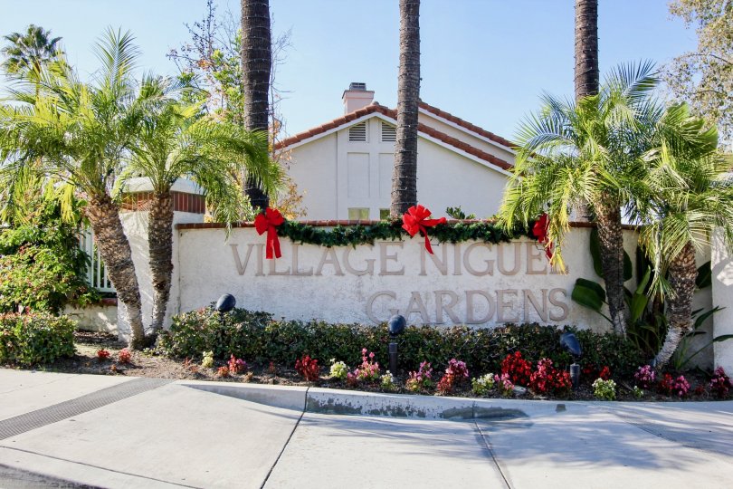 A villa at the Village Niguel Gardens with large palm trees and flowering plants