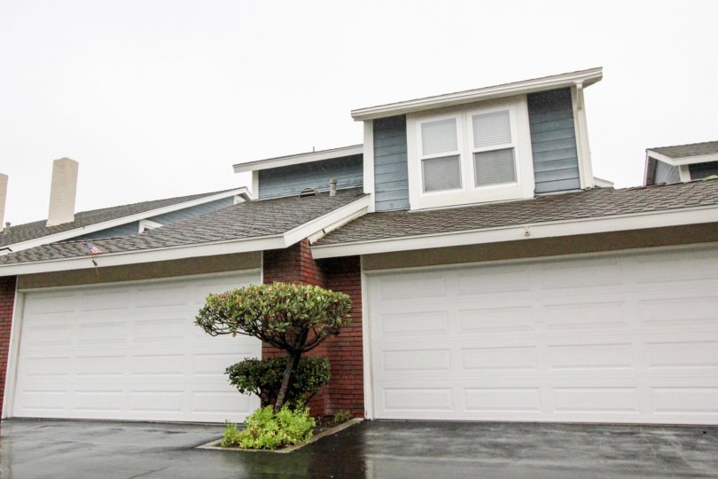 A SIGHT OF A BEAUTIFUL COTTAGE WITH THE CONTRAST OF GREY & WHITE COLOR & WITH THE FACILITY OF GARRAGE