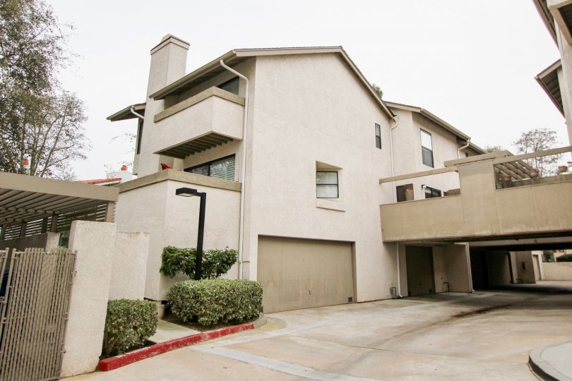 Side view with garage doors and driveway of Harbor Woods community, Newport Beach, CA