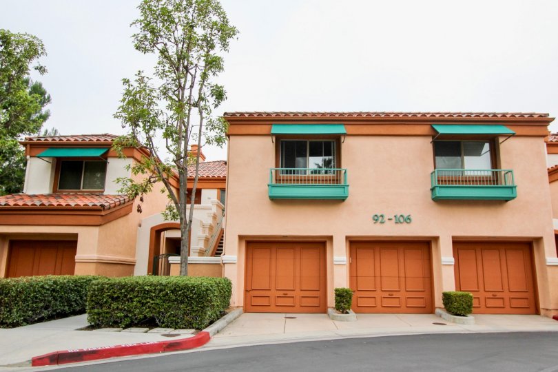 Front side view with garage doors and trees of Villa Point community, Newport Beach, CA